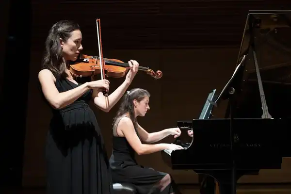 Jeanne playing the piano and Katia playing the violin